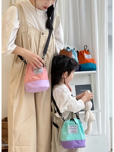 Detail of color-block nylon bucket bags showing adjustable straps and drawstring closure