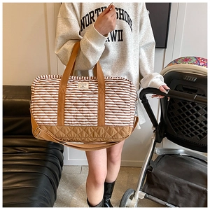 Sac à langer en toile rayée avec base renforcée sur une poussette en décor quotidien