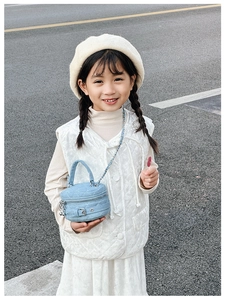 Detail of mini quilted blue denim bag with silver belt buckle and chain strap for girls