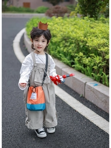 Detailed view of kids orange and blue bucket bag with Shion tag and adjustable strap