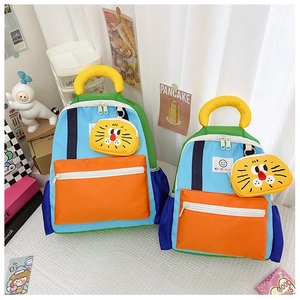Detail of color-block kids backpack with cute yellow lion charm and durable nylon fabric