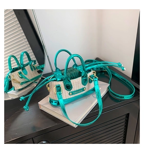 Détail du mini sac en paille avec garniture en cuir verni vert et cordons