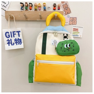 Close-up of color-block nursery school bag with cute green monster pendant and zipper pockets
