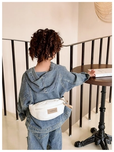 Vue arrière du sac banane enfant en cuir PU blanc avec écusson porté sur du denim