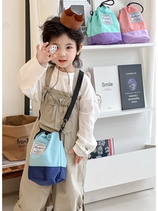 Detail of color-block kids bucket bag with drawstring closure and Fashion patch