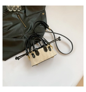 Vue détaillée du mini sac bandoulière en paille avec cuir verni noir et détails dorés