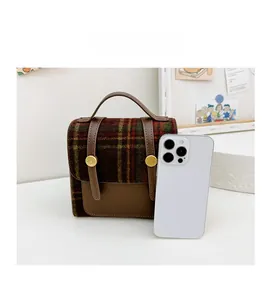 Detailed comparison of brown plaid children's mini backpack next to a smartphone