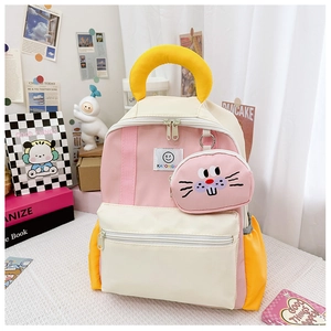 Close-up of pink and cream preschool backpack with cute cat pendant and yellow handle