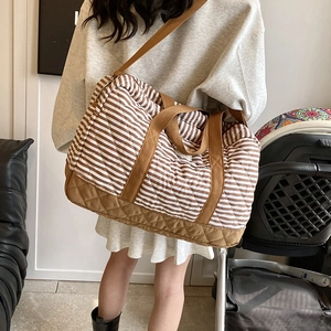 Grand sac fourre-tout en toile rayée avec détails matelassés marron sur un mannequin