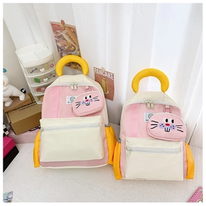 Detail of pink and beige kids backpack set with detachable cartoon animal round charms