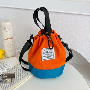 Detail of color-block drawstring bucket bag featuring blue and orange nylon fabric