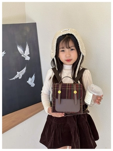 Girl wearing a vintage British style checkered kids backpack with brown leather details