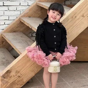 Ensemble mode fille avec cardigan noir, jupe tutu rose et petit sac matelassé blanc