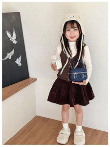Girl wearing a mini denim quilted chain bag with navy blue fabric and silver hardware
