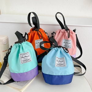 Detail of color-block drawstring bucket bags with adjustable straps in vibrant color options
