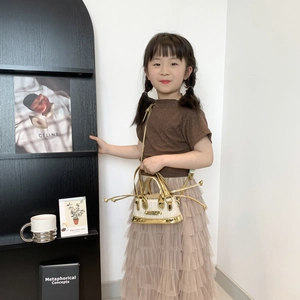 Mini sac bandoulière enfant en similicuir doré et tissé avec franges sur modèle