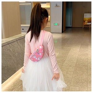Vue arrière d'un sac banane rose à motif licorne porté par un enfant dans un couloir