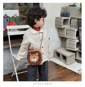 Detail of handmade crochet lion bag with 3D yarn mane on a knit cardigan background