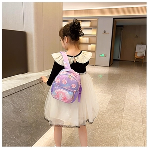 Young girl wearing purple gradient mermaid backpack with shell print in modern hall