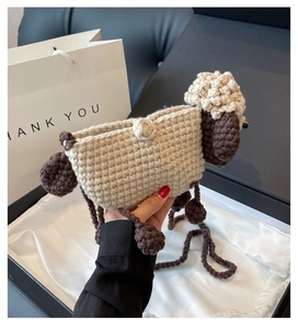 Detail of handmade knit sheep crossbody bag with fluffy texture and crochet shoulder strap