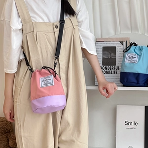 Contrast color bucket crossbody bag with drawstring closure and fashion label