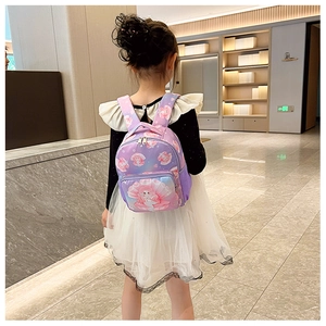 Detail of cute purple mermaid backpack showing straps and zipper on a child model