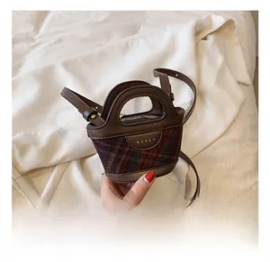 Detail of mini bucket bag with checkered tweed, leather trim and MARAH logo