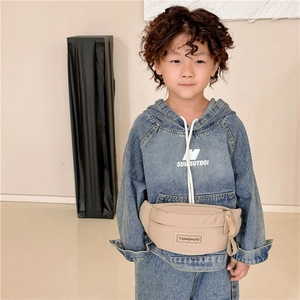 Sac banane enfant en toile beige avec étiquette en cuir porté par une petite fille