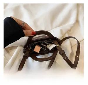 Close-up showing internal capacity of the dark brown mini bucket bag with daily items
