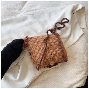 Détail d'un petit sac bandoulière au crochet fait main avec texture tricotée brune