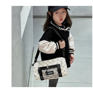 Detailaufnahme der Kinder-Umhängetasche mit Retro-Monogramm-Print und schwarzem Reißverschluss