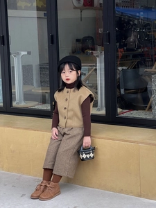 Fashionable young girl wearing autumn winter outfit with black and white checkered handbag