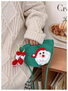 Detailed knit texture of green Santa Claus crochet crossbody bag with small boot charms