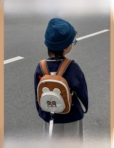Detailed view of cute Corgi embroidery and 3D ears on child's brown oxford backpack