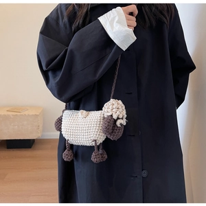 Detail of handmade crochet sheep crossbody bag showing knitted texture and 3D design