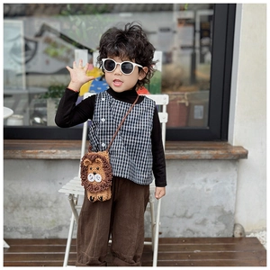 Outdoor shot showing a child wearing a handmade crochet lion crossbody bag for girls