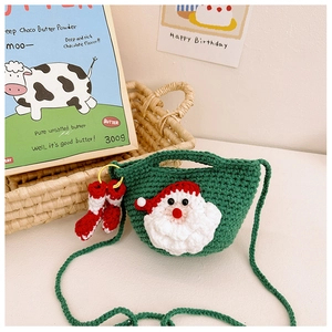 Detail of green handmade crochet Christmas bag with 3D Santa and tiny socks charm