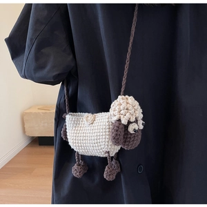 Detailed close-up of handmade crochet sheep crossbody bag with knitted white and brown yarn