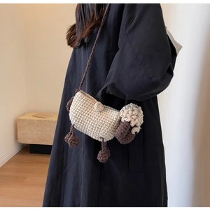Detailed view of handmade crochet sheep crossbody bag with woven texture and cute design