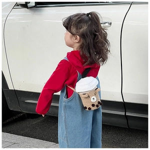 Detail of a handmade crochet boba tea bag for kids featuring a soft straw and pearl texture