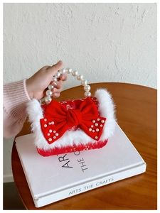 Détail du sac rouge pour fille avec poignée en perles et bordure en fausse fourrure