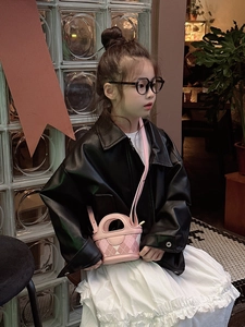 Close-up of pink quilted mini tote bag with stitching detail on a stylish child model