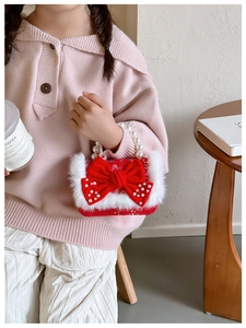 Détail du sac en peluche rouge pour filles avec nœud en velours et poignée en perles