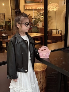 Detail of a black faux leather kid's jacket featuring a lapel and metallic silver buttons