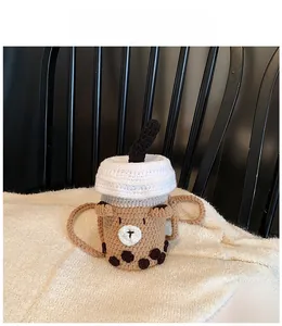 Detail of handmade crochet bear bubble tea bag with pearl accents and knit strap
