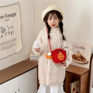 Handmade crochet pumpkin shoulder bag for kids paired with a cozy beige hooded knit sweater