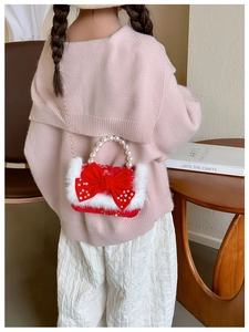 Détail du sac rouge pour fille avec grand nœud, perles et bordure en fausse fourrure blanche