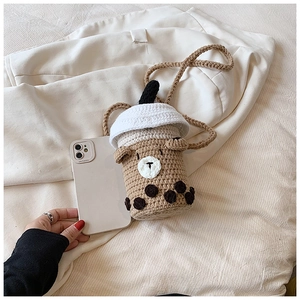 Detail of a handmade crochet bubble tea mini bag showing compact size beside a smartphone