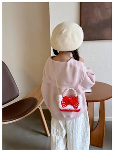 Détail du sac à main rouge pour enfant avec poignée en perles et bordure en peluche