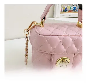Detailed view of pink quilted PU leather bucket bag with gold clasp and chain strap